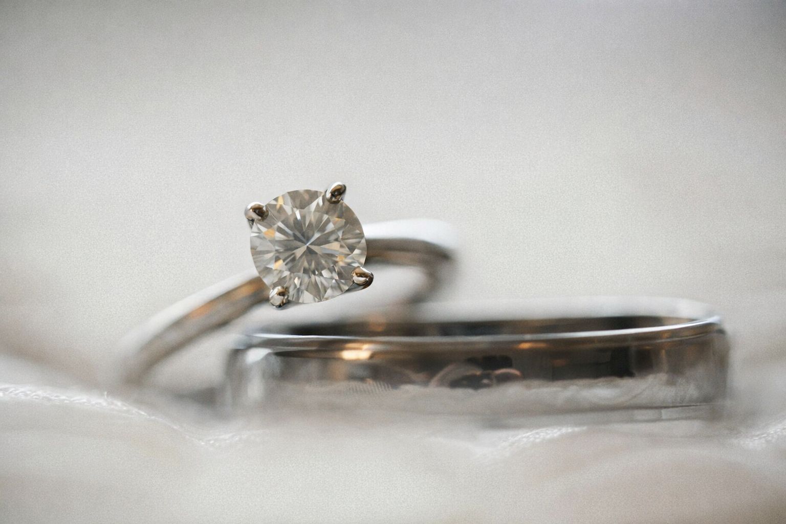 En gnistrande diamantring och en slät guldring mot en ljus bakgrund.