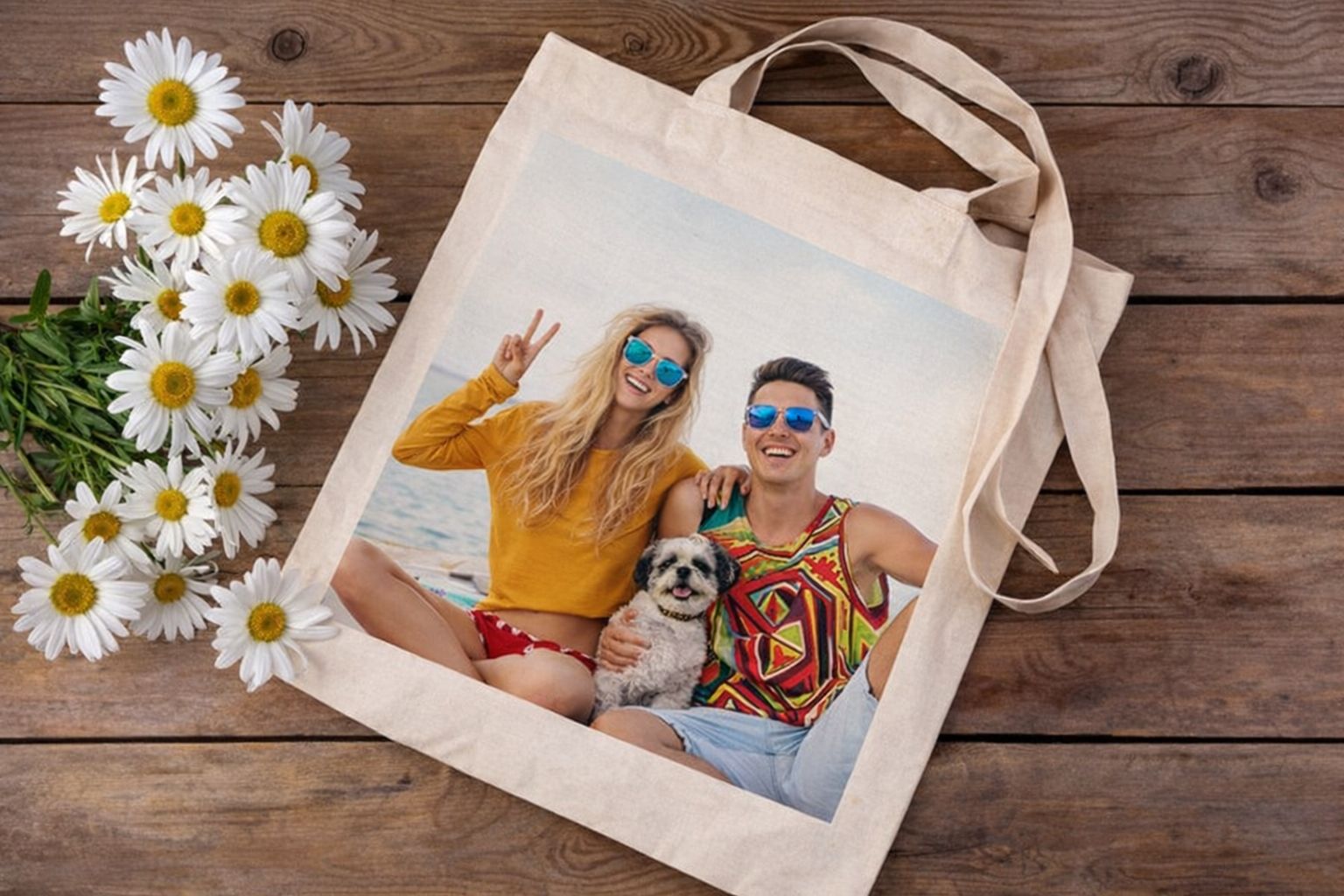 En personlig tygpåse med tryck på ett träbord bredvid prästkragar.