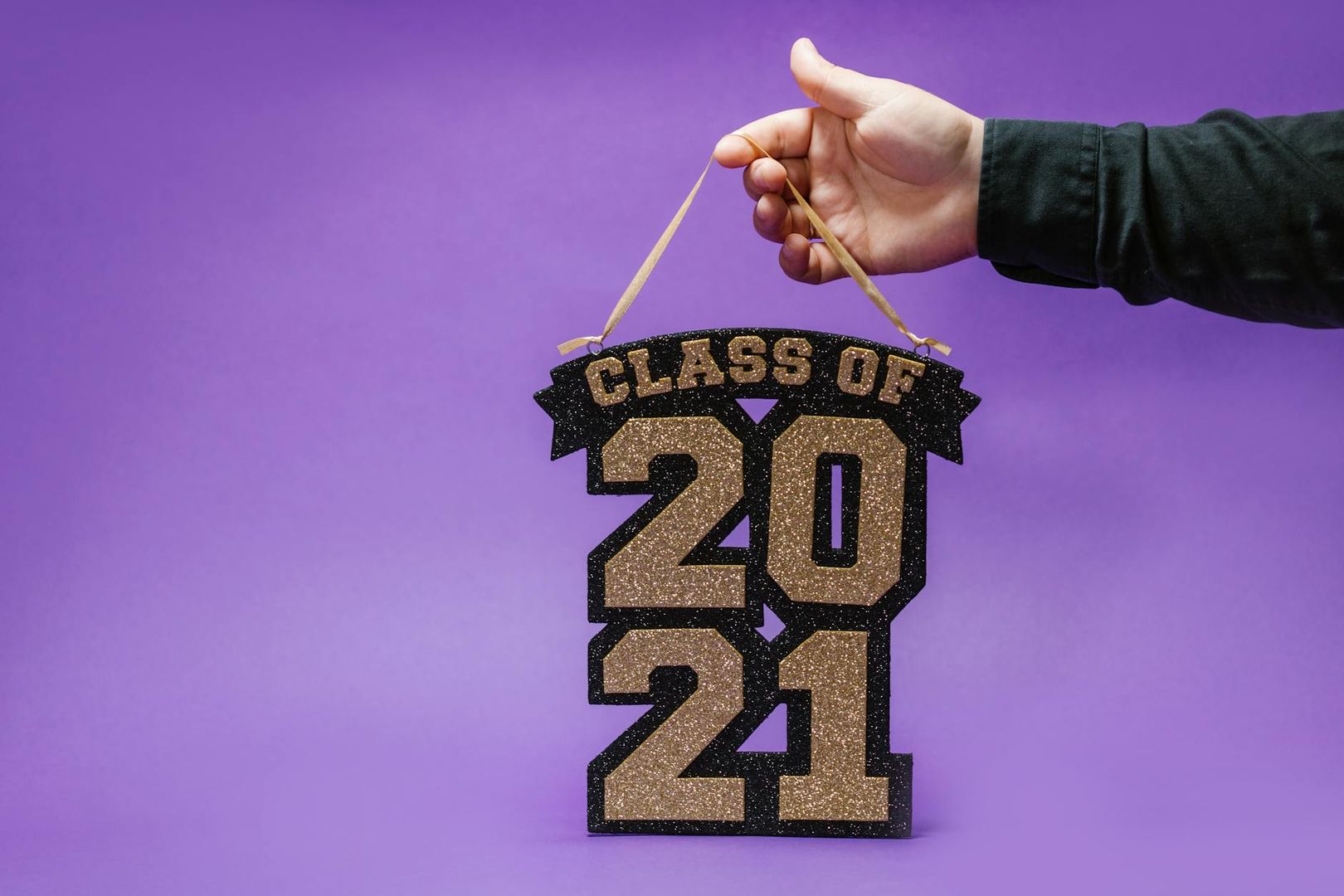 En person håller upp en studentskylt med texten Class of 2021.