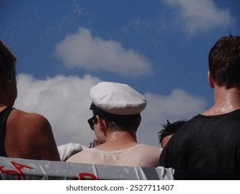 Studenter i studentmössor firar utomhus under en blå himmel.